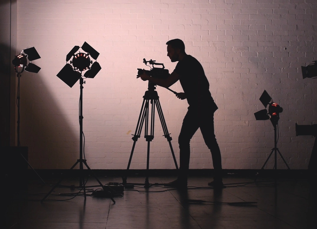 A silhouette of a person operating a camera.